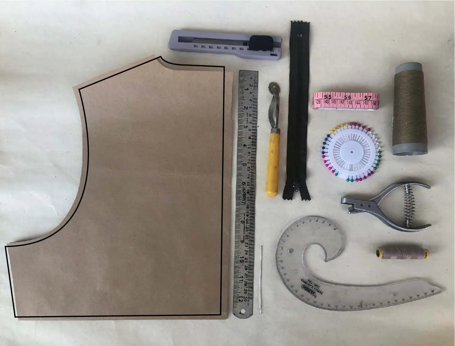Collection of sewing tools and organic clothing materials on a white background